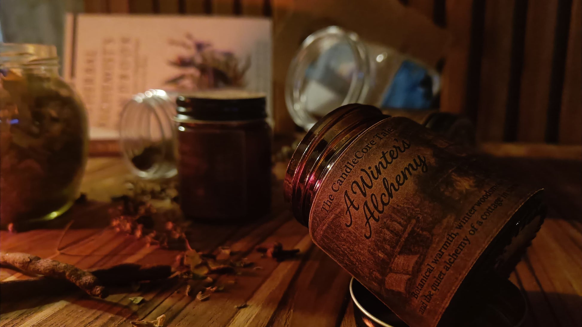 A winter's Alchemy soy candle styled in warm low light with rustic elements, evoking a quiet winter evening ritual.