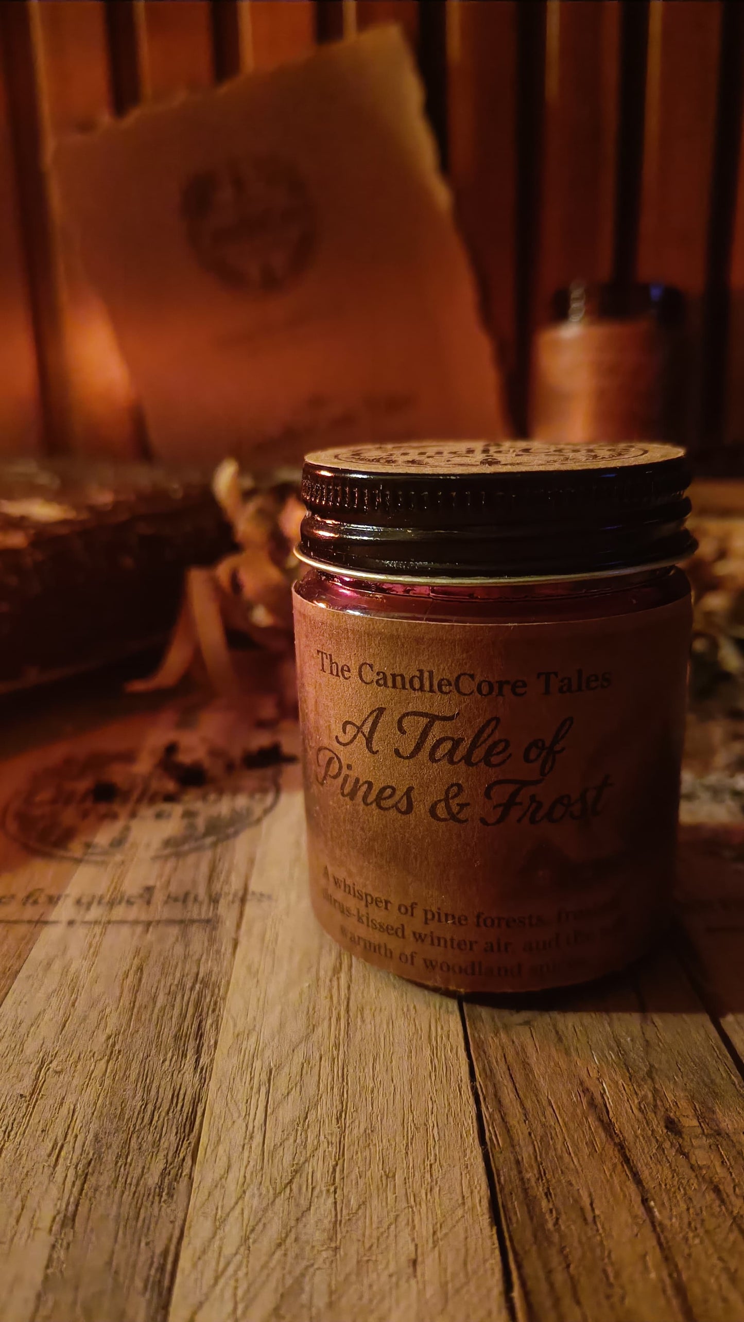 A Tale of Pines & Frost soy candle shown up close in warm winter light withthe label clearly visible on a wooden surface.